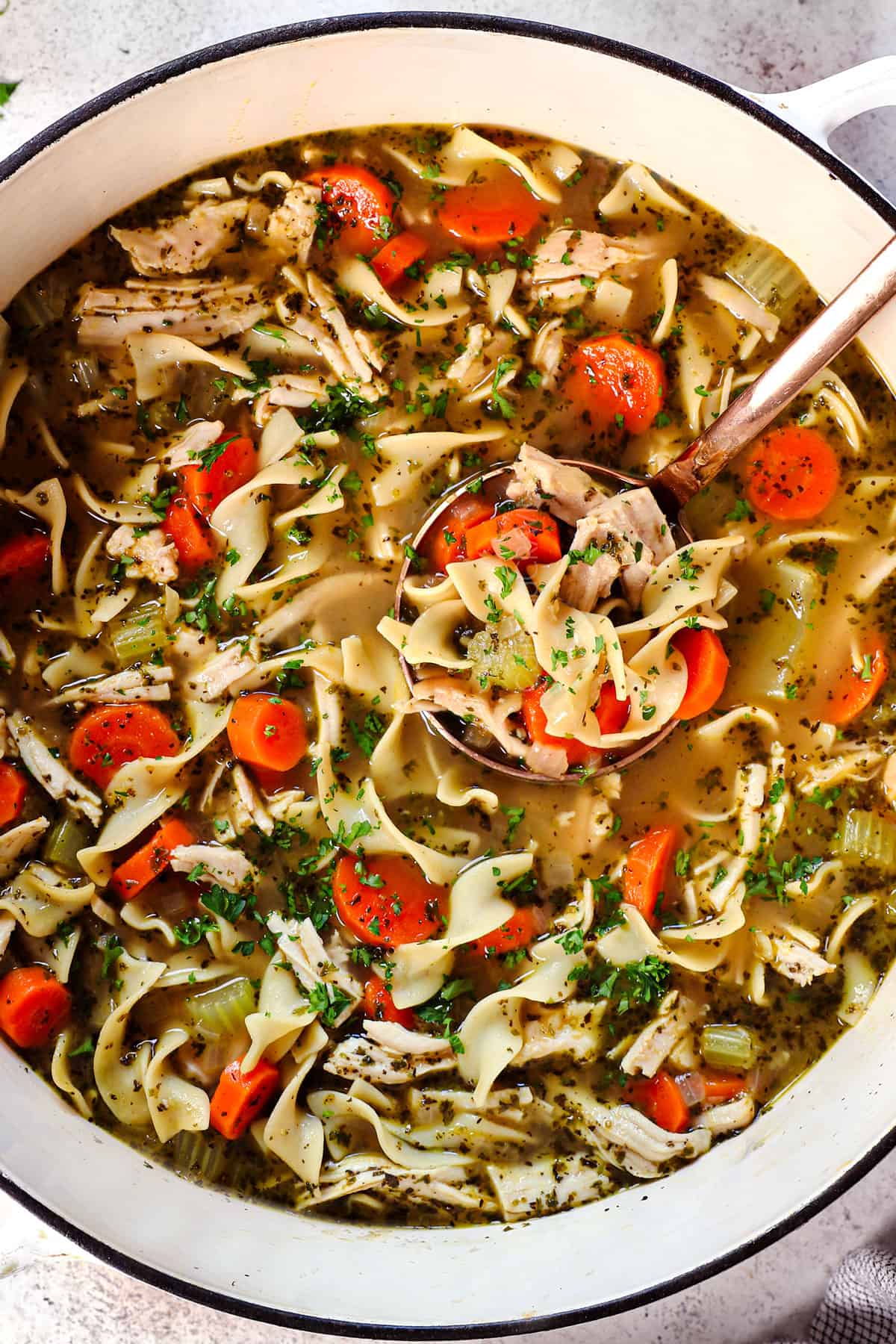 top view of a pot of turkey noodle soup showing how chunky the soup is