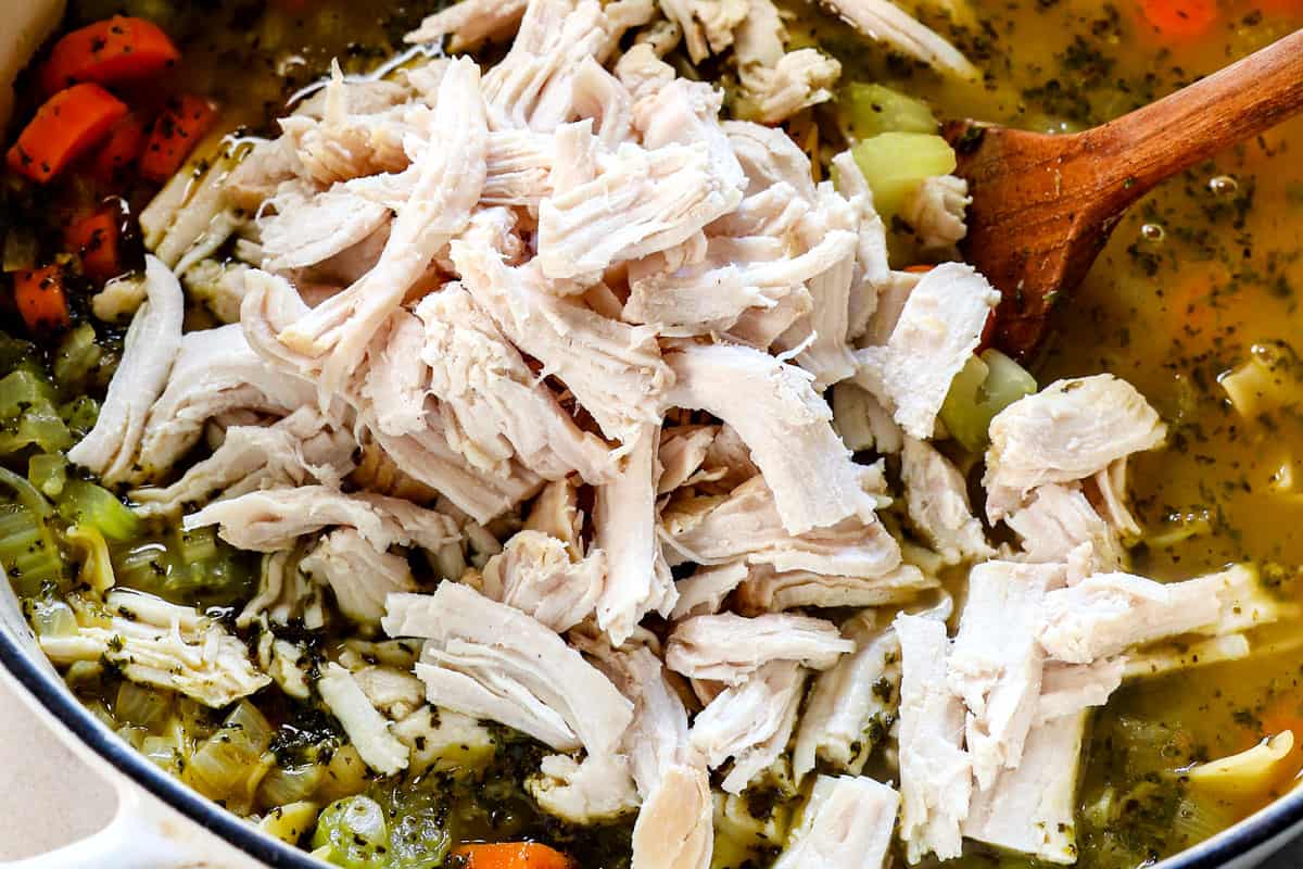 showing how to make turkey soup by adding the shredded turkey to the soup