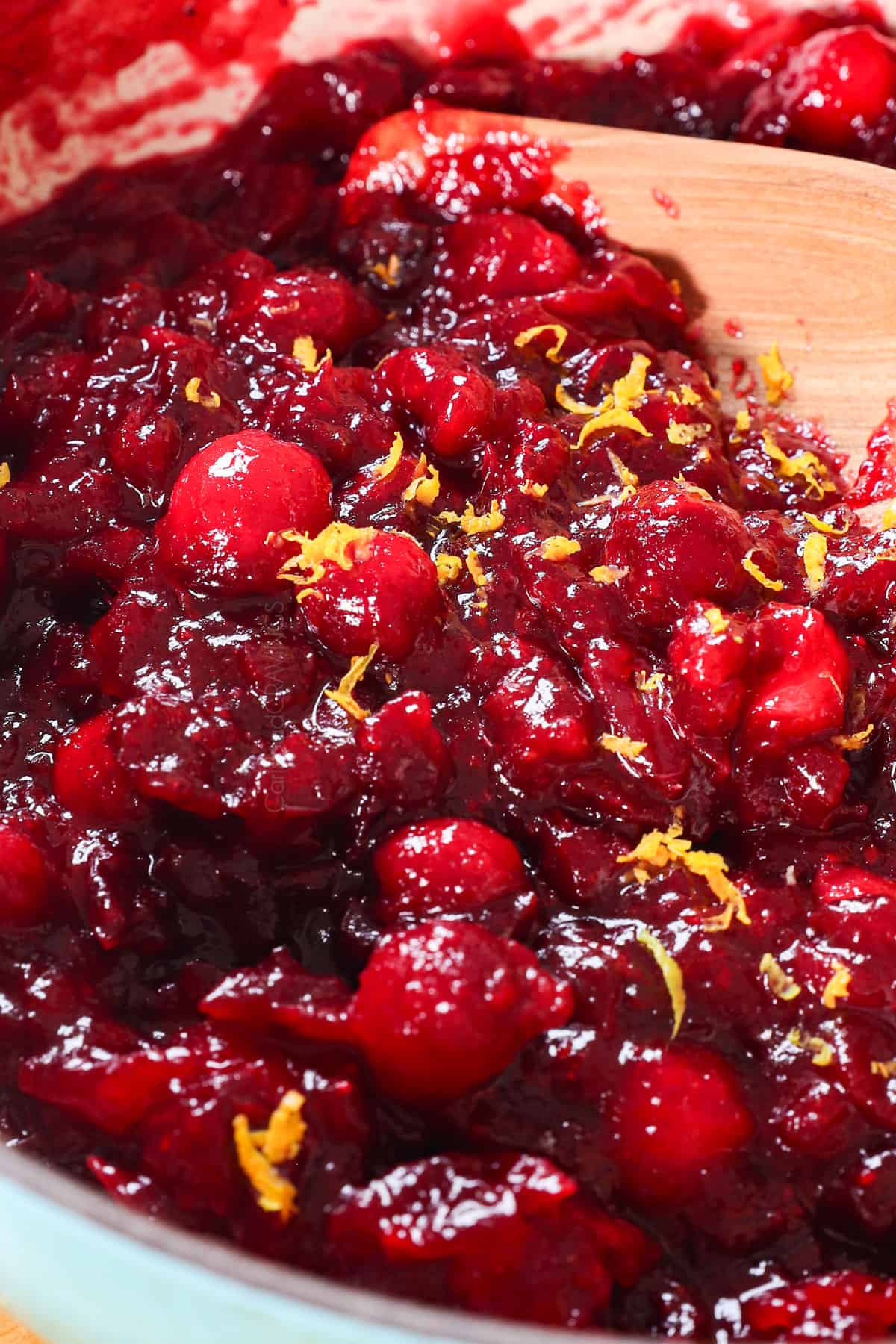 stirring fresh cranberry sauce showing its texture and consistency