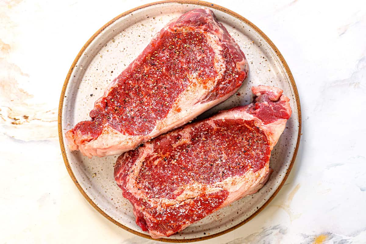 showing how to make ribeye steak by seasoning the steak with kosher salt and pepper