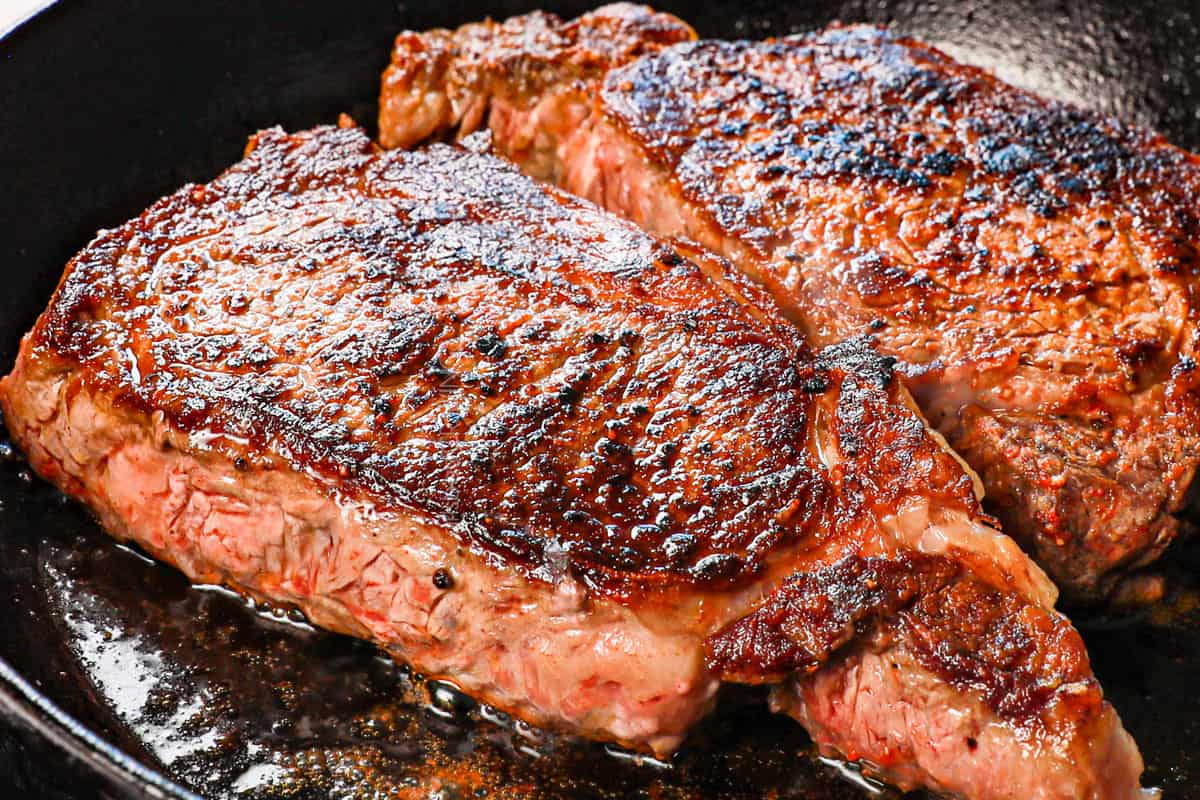 showing how to cook ribeye by pan searing in a cast iron pan