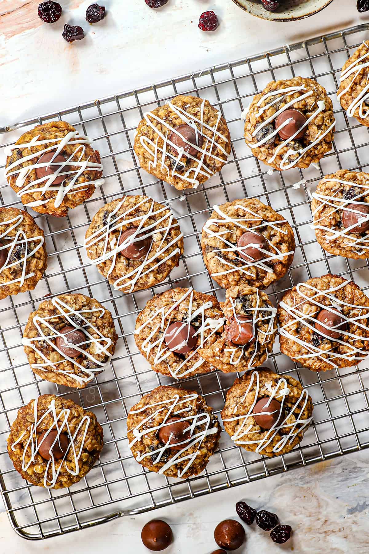 top view of cherry blossom cookies drizzled with white chocolate on a cooling rack