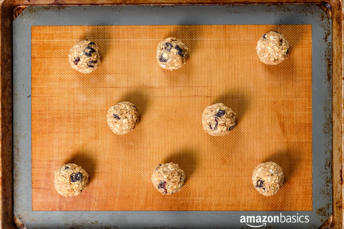 showing how to make cherry blossom cookie by rolling the dough into balls and spacing on a baking sheet