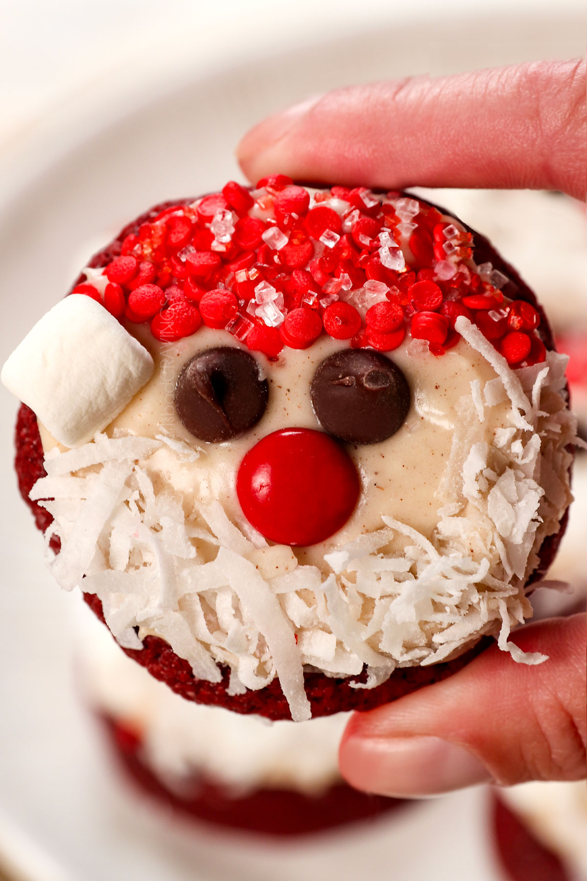 up close of holding a red velvet cookie decorated like santa