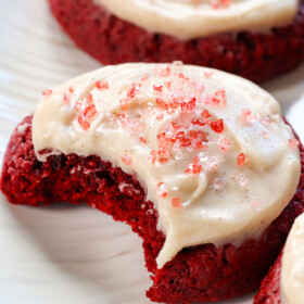 up close of red velvet cookies with a bite taken out showing how soft and chewy they are