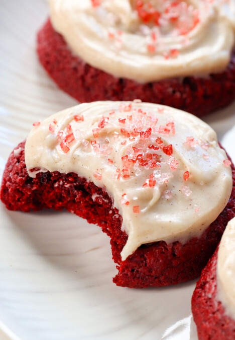 up close of red velvet cookies with a bite taken out showing how soft and chewy they are