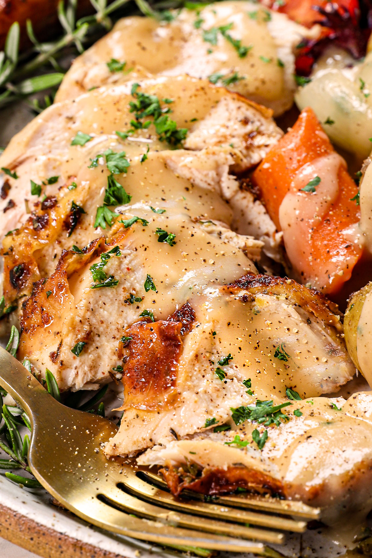 serving roast chicken recipe on a plate with potatoes, carrots, gravy and salad