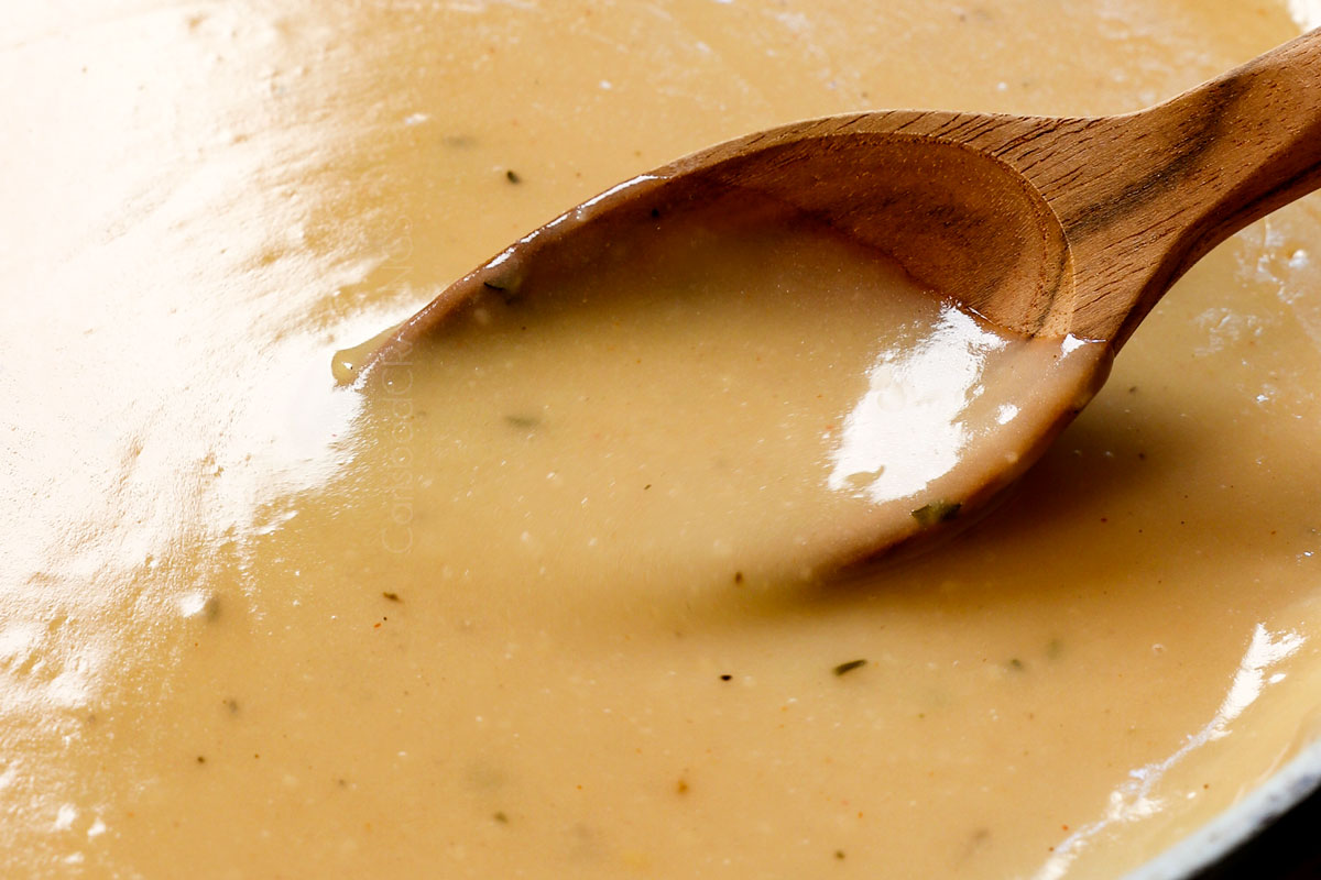 showing how to roast a whole chicken by simmering the chicken gravy until thickened