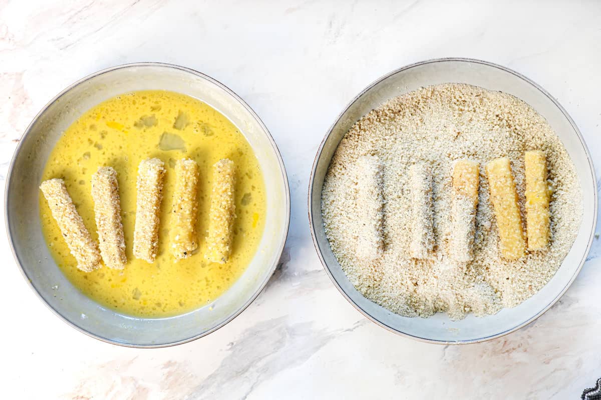 showing how to make mozzarella sticks by breading the cheese sticks in eggs and panko for a second time