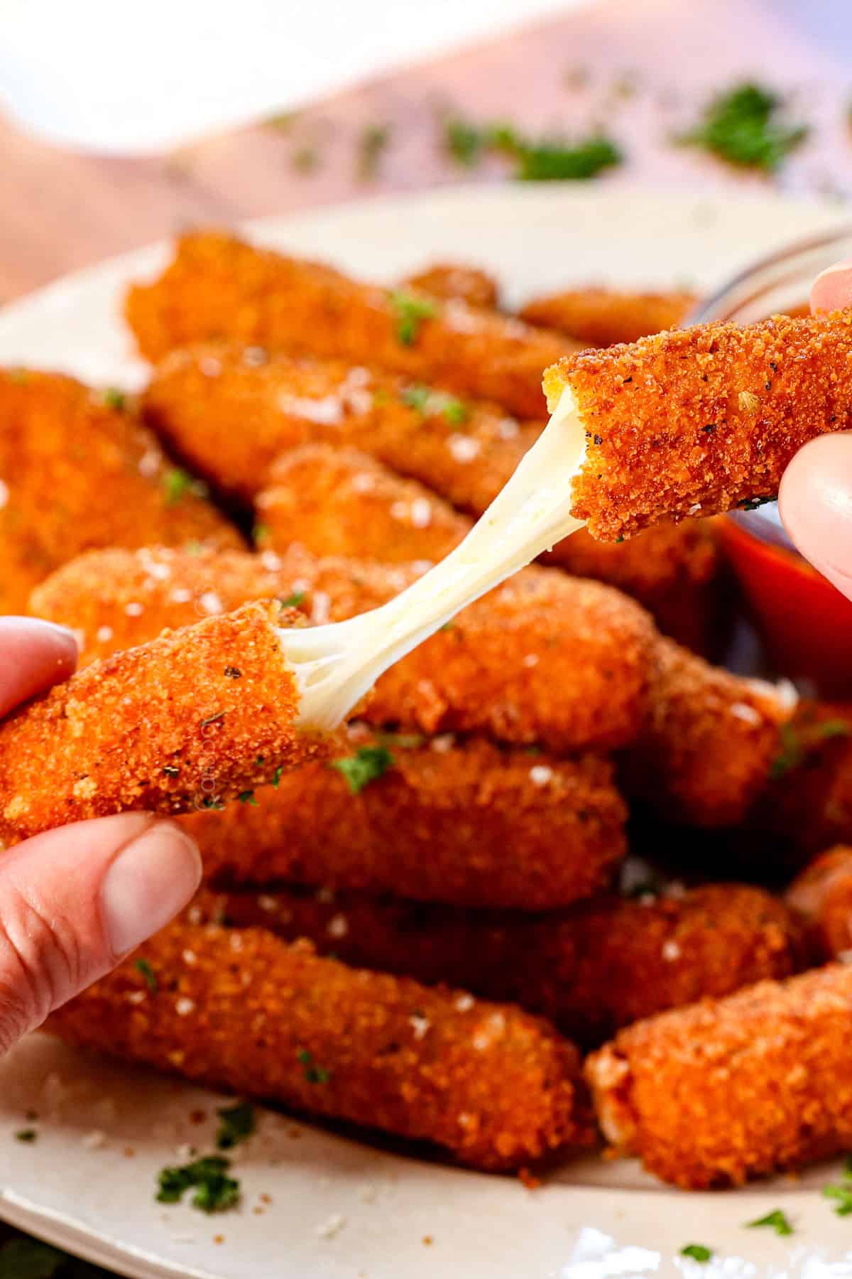 showing how cheesy the  mozzarella cheese sticks are by pulling a cheese stick apart