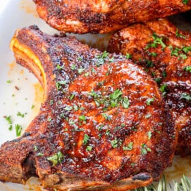 up close of pork chop air fryer spice rubbed and garnished with fresh parsley