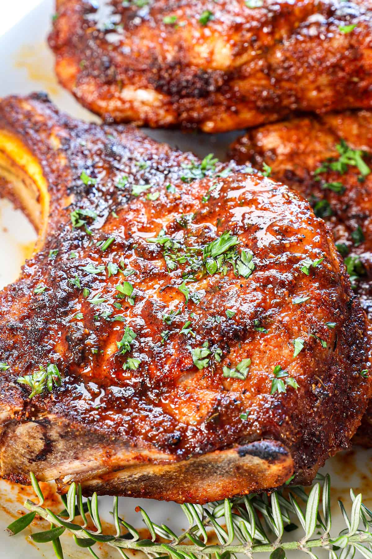 up close of pork chop  air fryer spice rubbed and garnished with fresh parsley