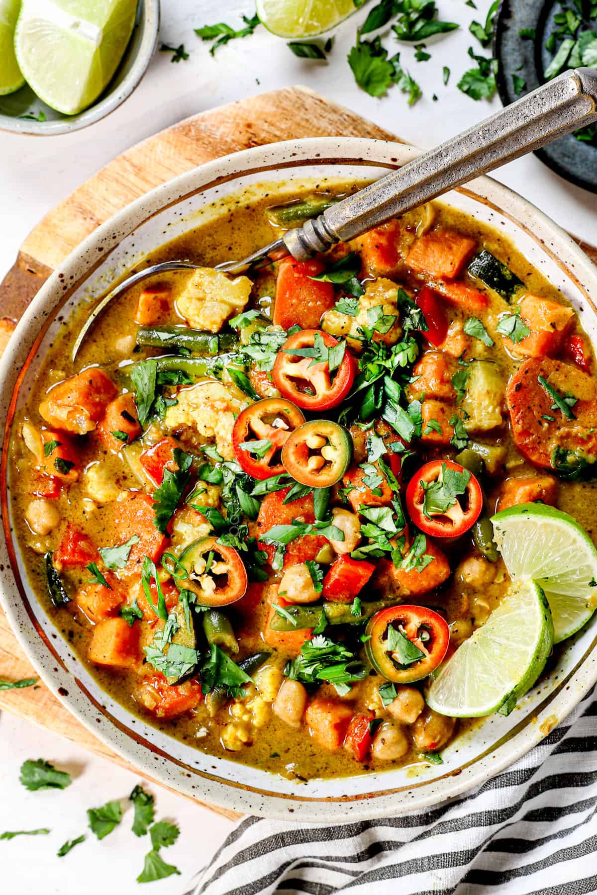 a bowl of easy vegetable soup topped with chili peppers and lime slices