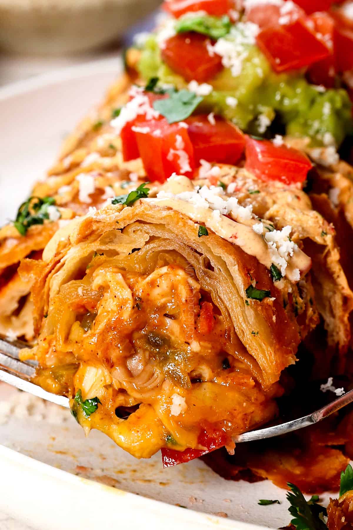 up close of a bite of chimichanga showing the crispy tortilla and cheesy chicken 