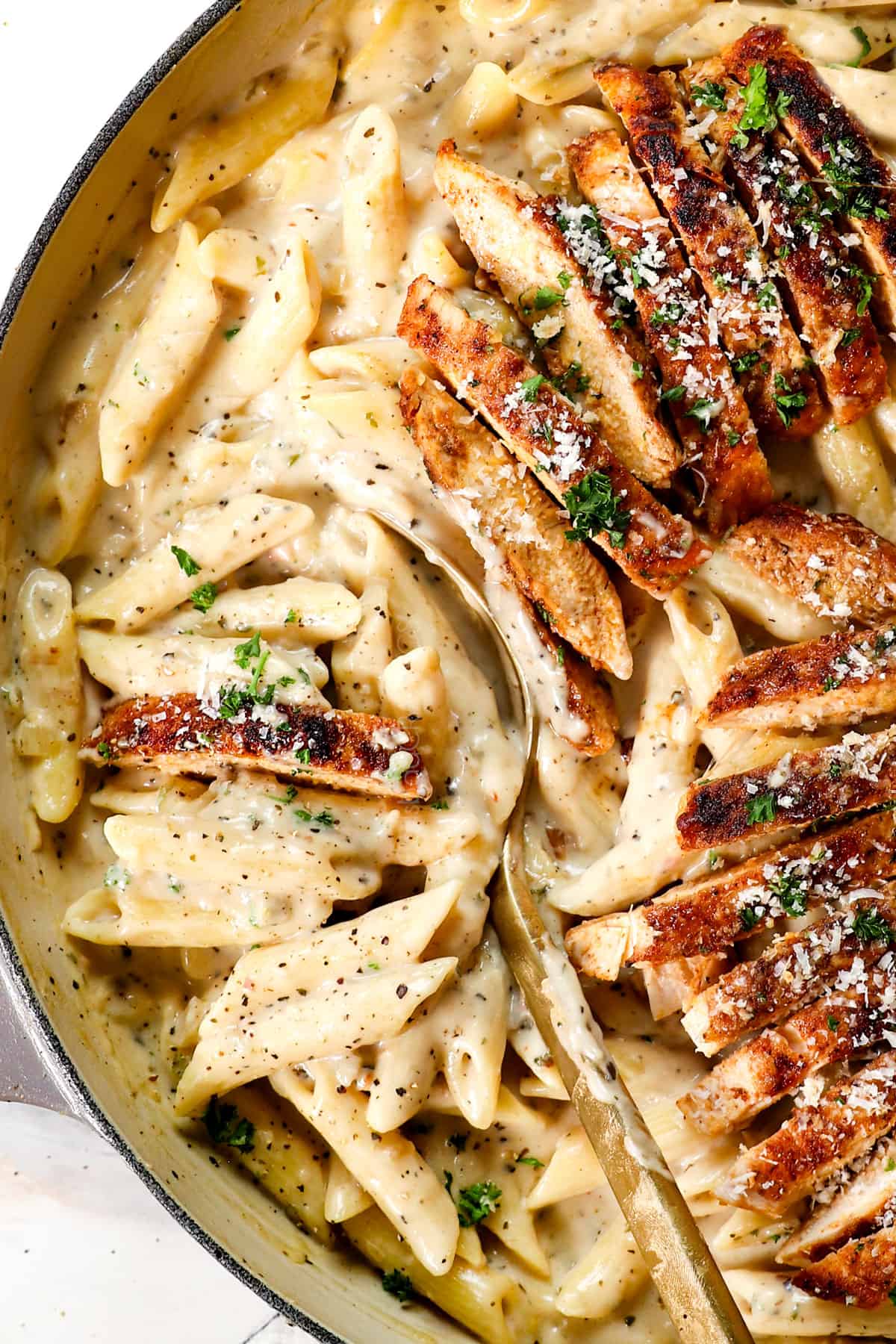up close a ladle of parmesan garlic chicken pasta with penne