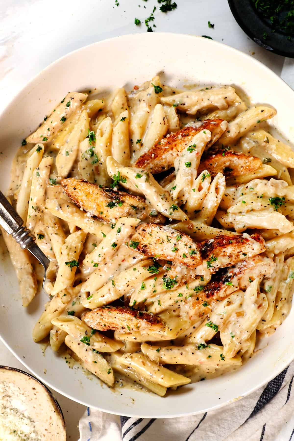 top view of a plate showing how to serve chicken garlic parmesan pasta garnished with Parmesan and parsley