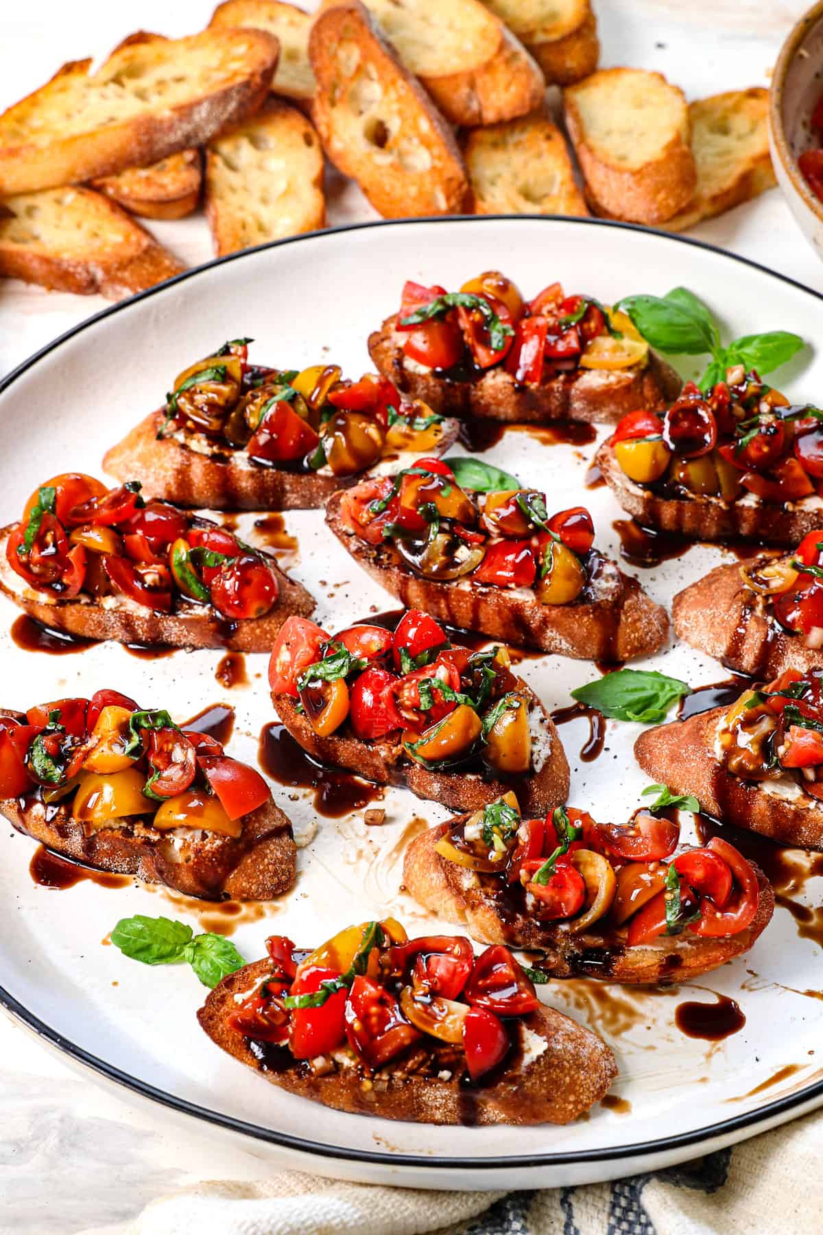 best bruschetta recipe being served on a platter drizzled with balsamic glaze