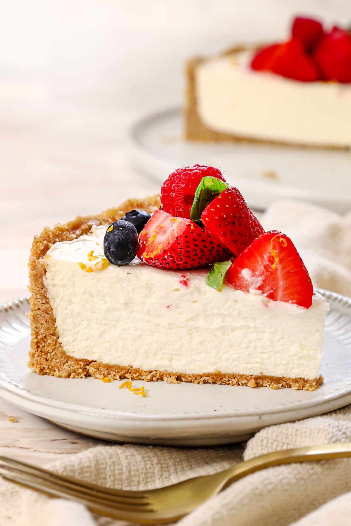 a slice of no-bake cheesecake recipe on a plate garnished with berries