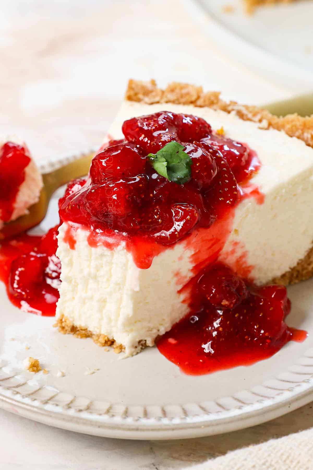 cheesecake recipe no bake served with strawberry sauce over top (showing serving options)