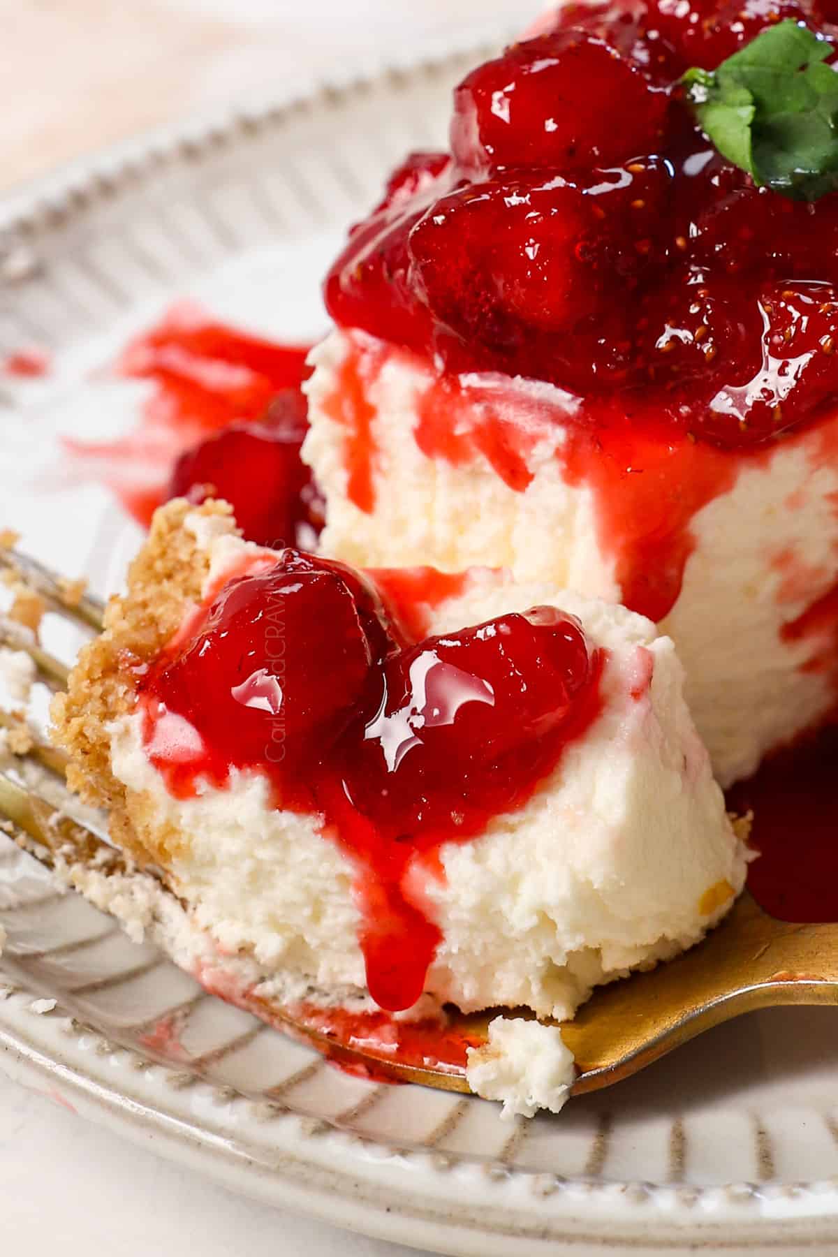 up close of a bite of easy no bake cheesecake recipe with strawberry sauce showing how rich and creamy it is