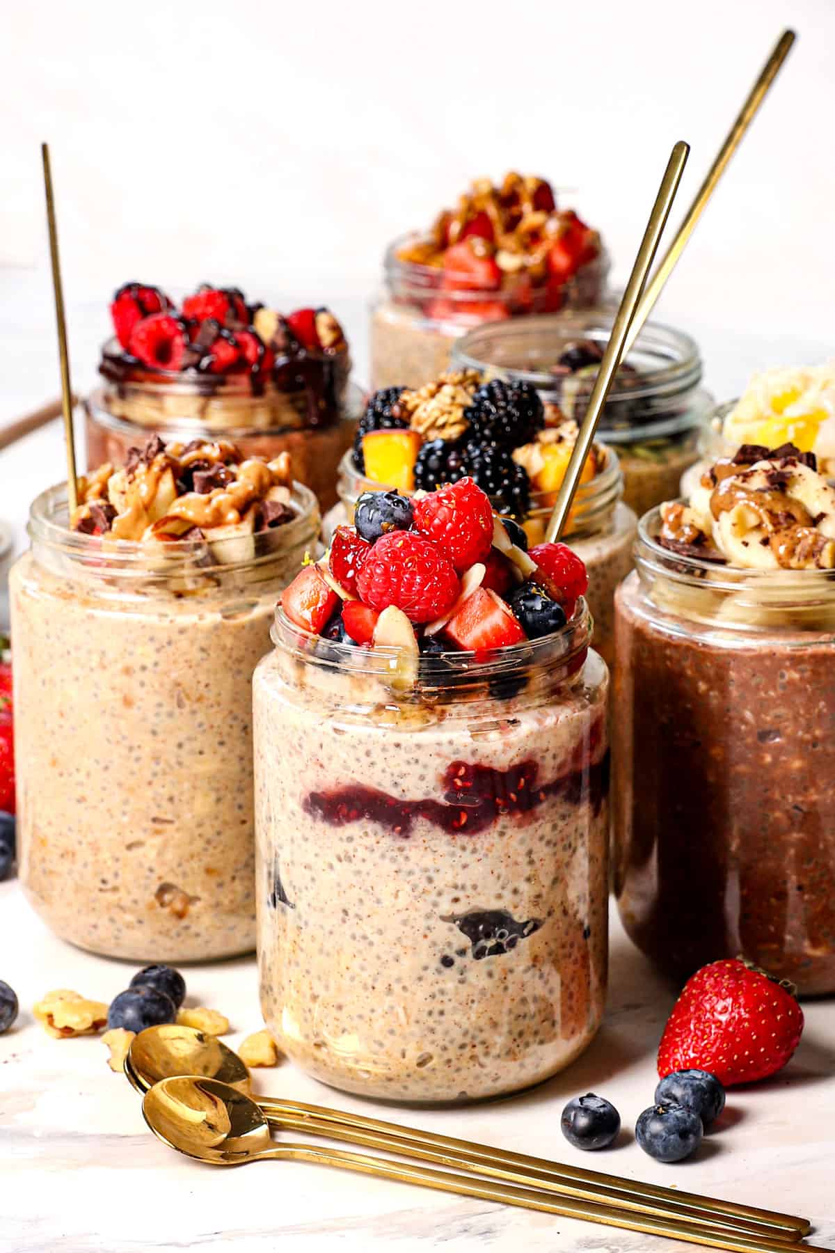 overnight oats recipes lined up in jars with spoons