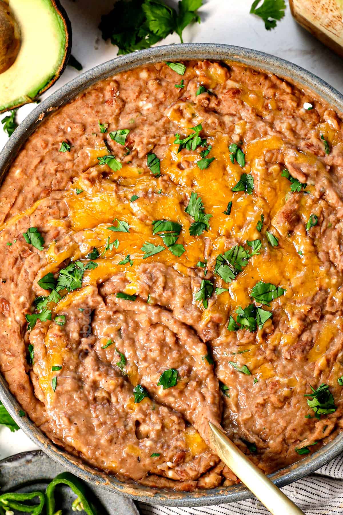 best refried beans being served with melted cheddar cheese on top