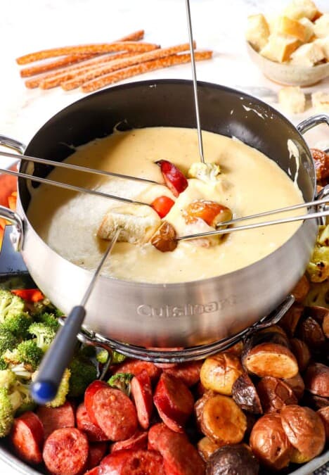 fondue recipe with dippers being dipped in the cheese