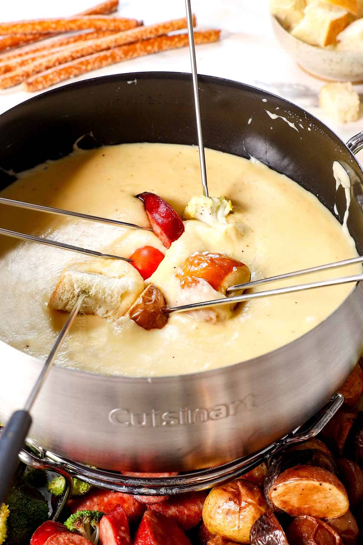 fondue recipe with dippers being dipped in the cheese