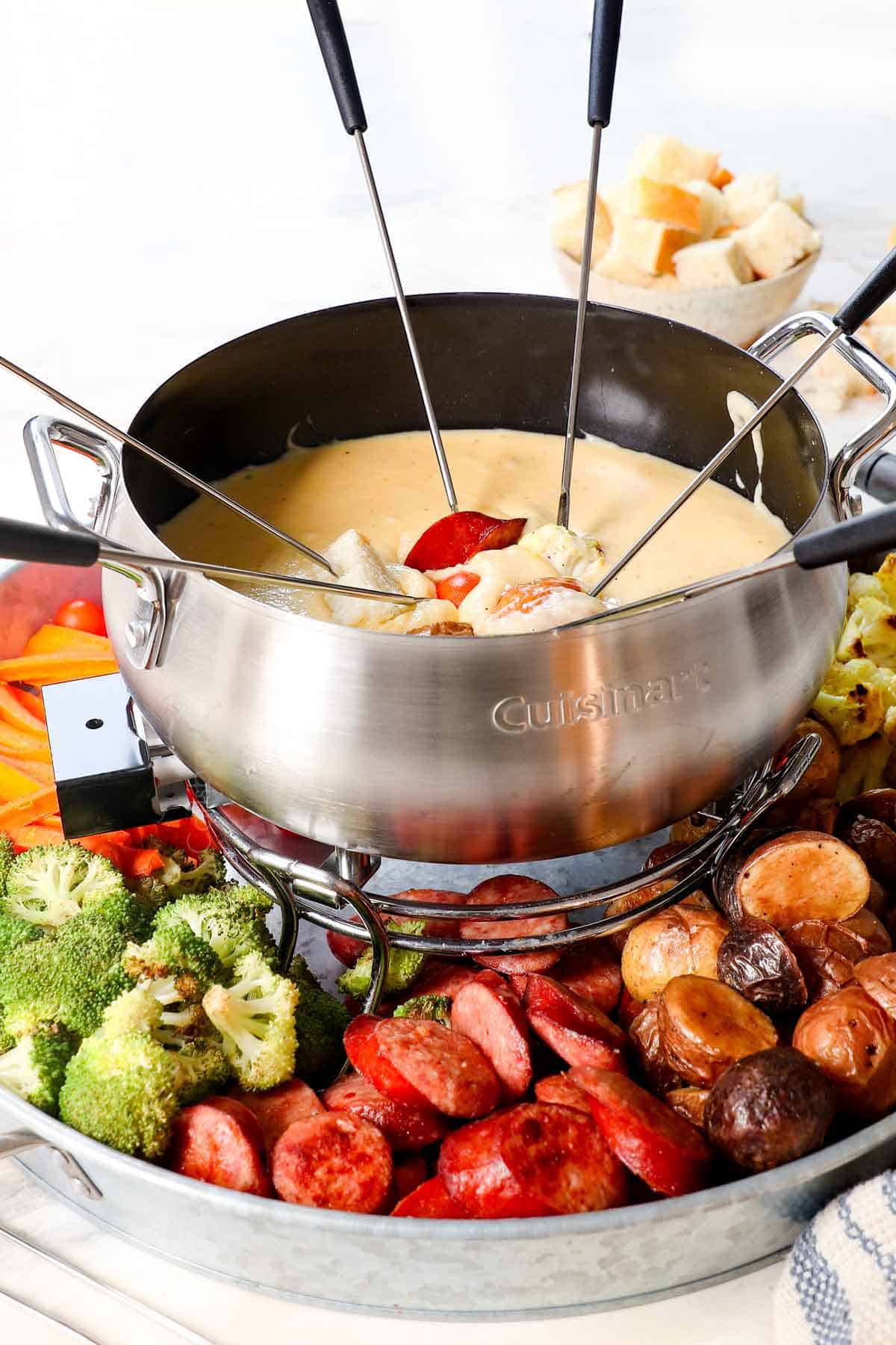 showing how to make fondue by serving in a fondue pot with dippers
