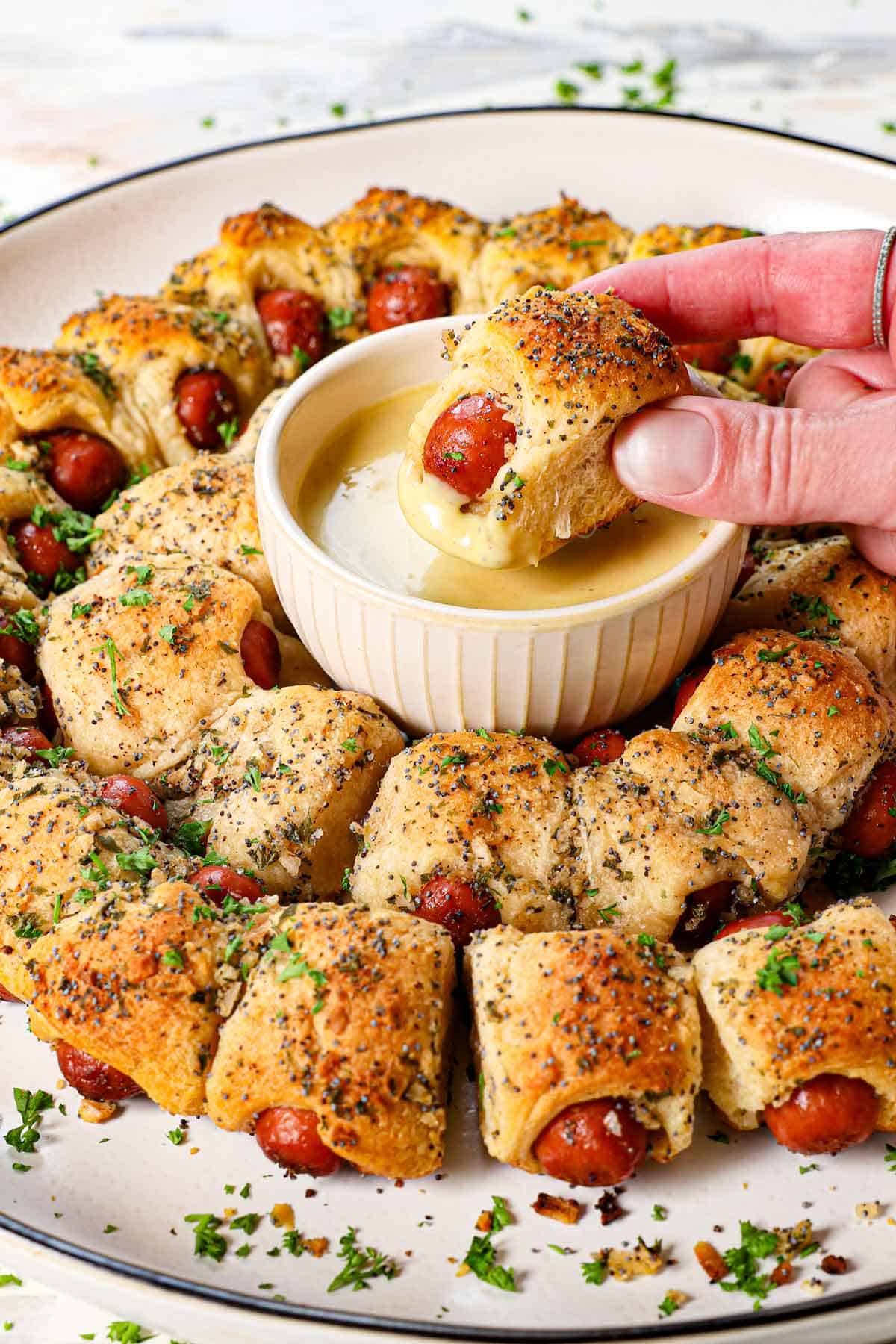 dipping pig in a blanket in honey mustard