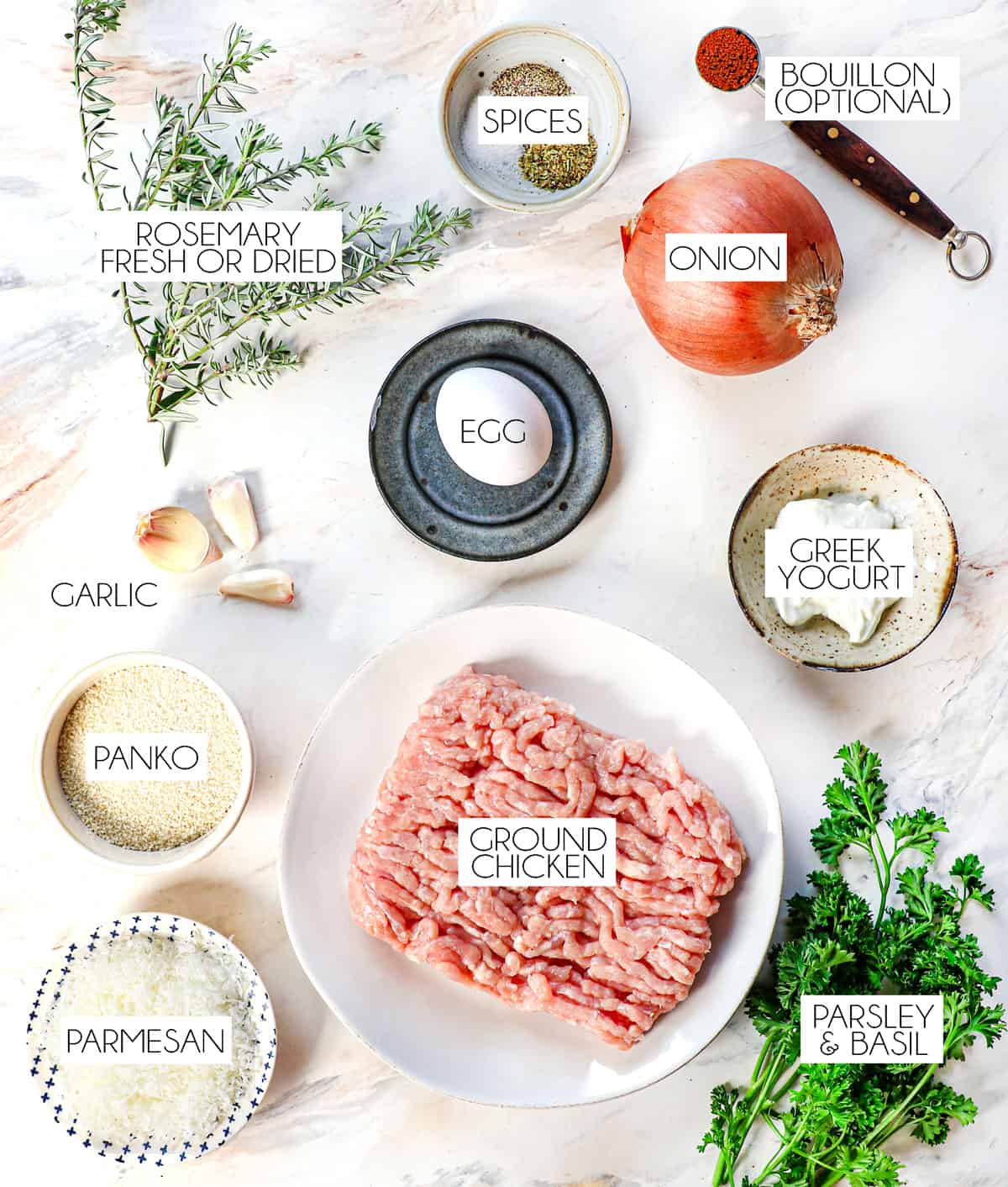 top view of chicken meatballs ingredients: ground chicken, egg, onion, garlic, Parmesan, panko, Greek yogurt, spices, egg, parsley,. rosemary, basil, beef bouillon