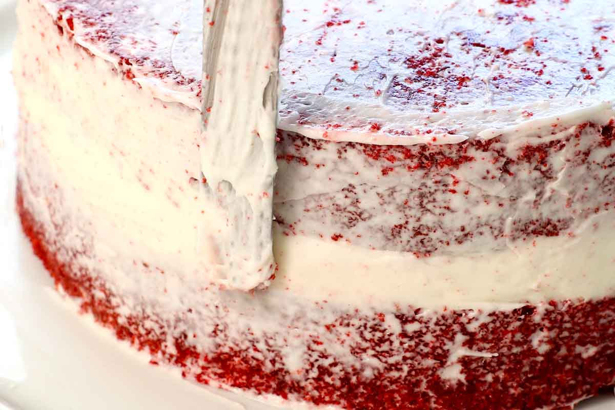 showing how to make red velvet cake by creating a crumb layer before frosting the whole cake