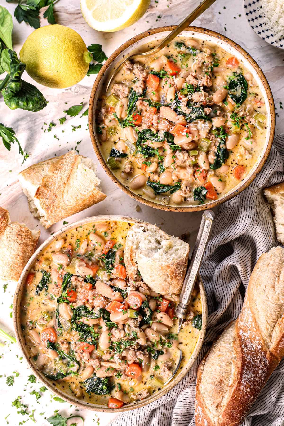 top view of Tuscan white bean soup served in two bowls garnished with Parmesan