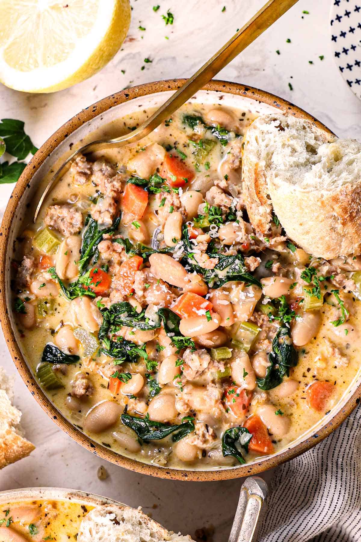 kale and white bean soup being served in a bowl with bread