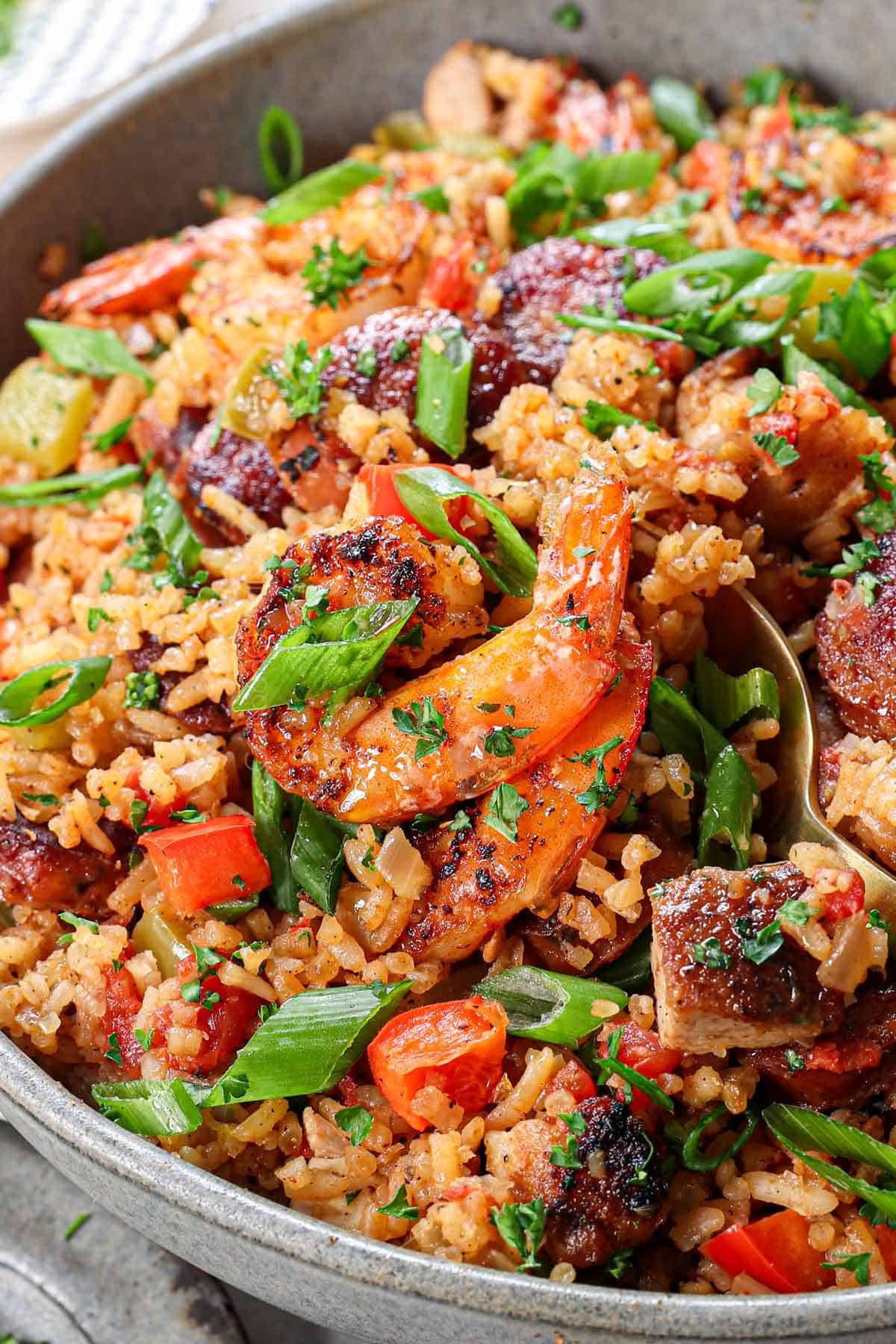 up closer of a fork scooping up best jambalaya recipe showing the juicy shrimp and fluffy rice