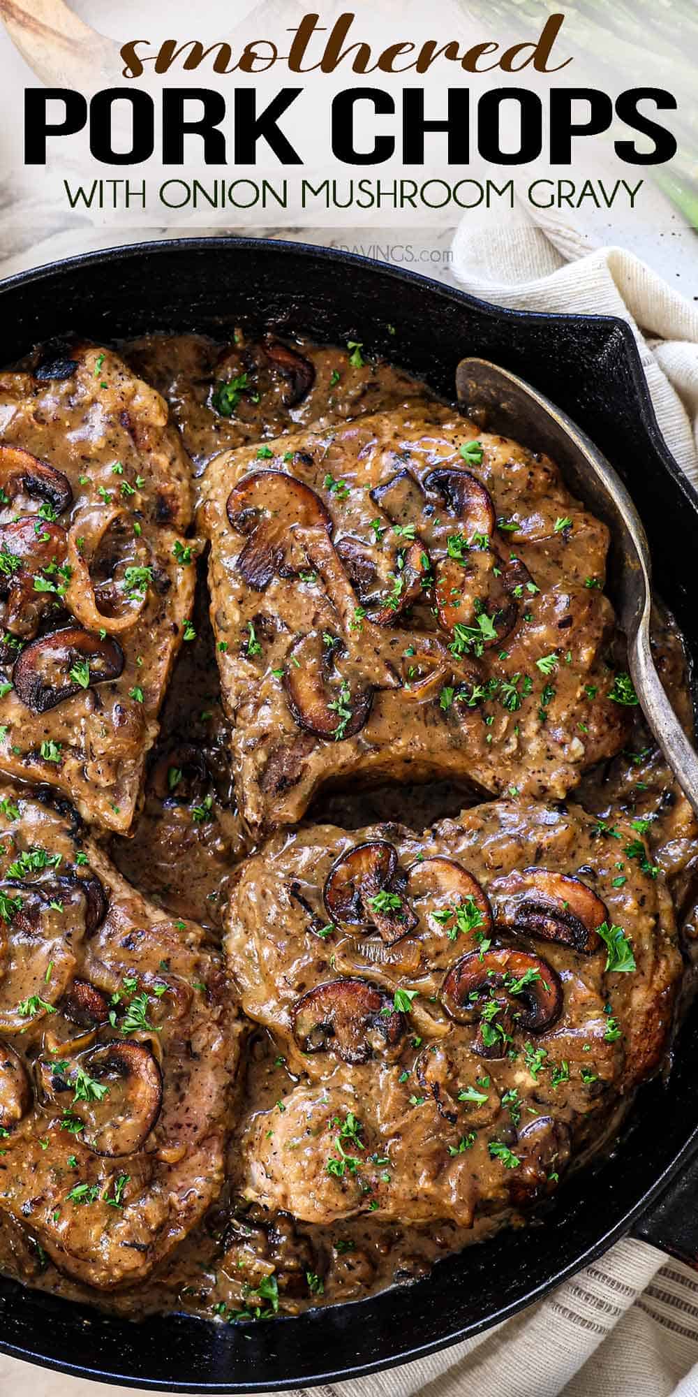 top view of smothered pork chops recipe in a skillet with mushroom and onion gravy