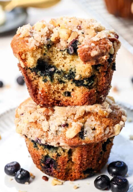 up close of blueberry muffin recipe with a bit taken out showing how moist and tender the muffins are