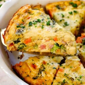 holding up a slice of crustless broccoli quiche showing how it holds its shape