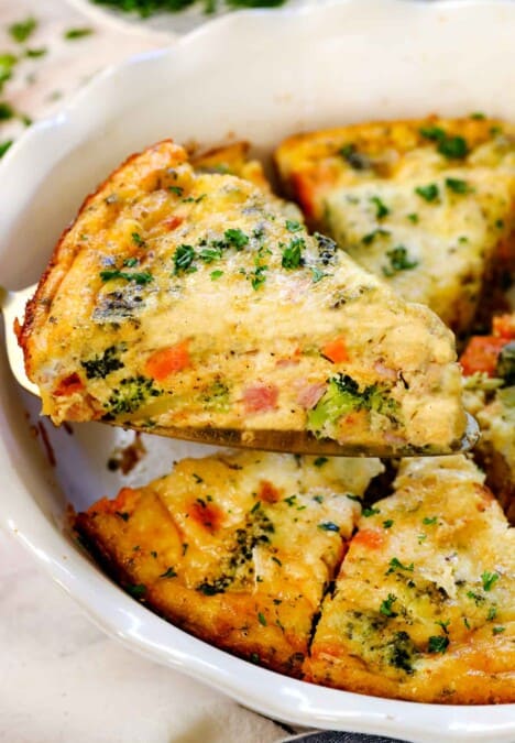 holding up a slice of crustless broccoli quiche showing how it holds its shape