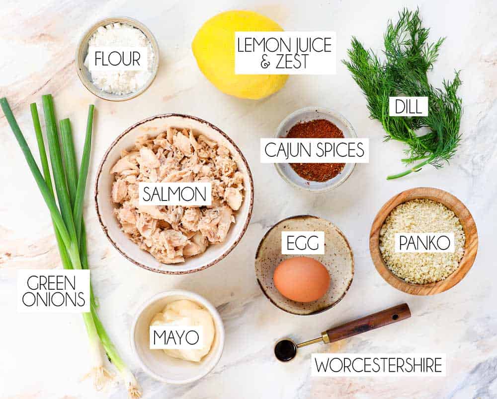 top view of salmon croquette ingredients: salmon, egg, flour, green onions, panko, mayonnaise, green onions, Cajun spices, dill, lemon juice and zest