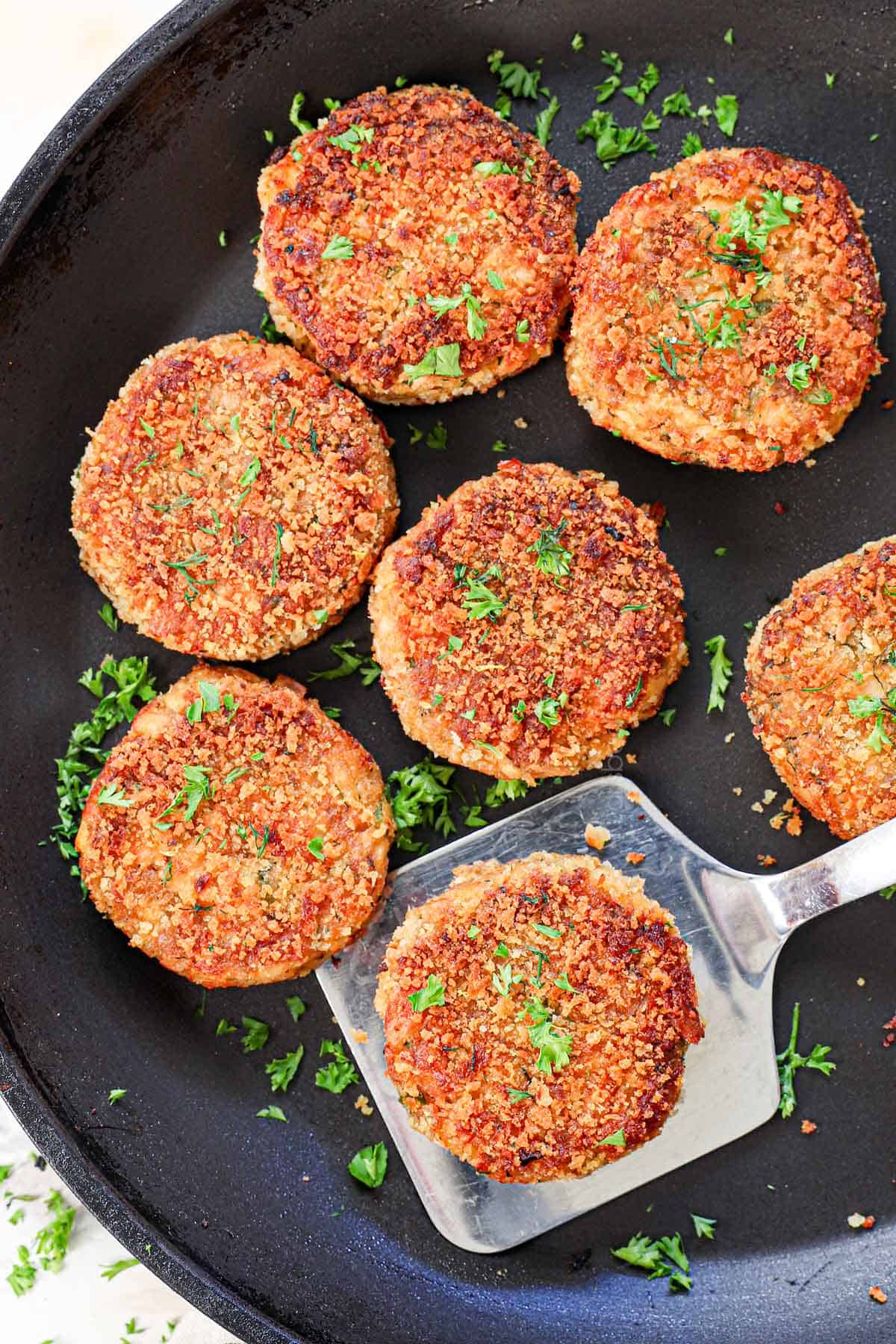 showing how to make salmon croquette recipe in a skillet by pan frying until golden and crispy