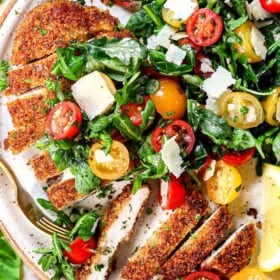 top view of chicken Milanese topped with arugula salad