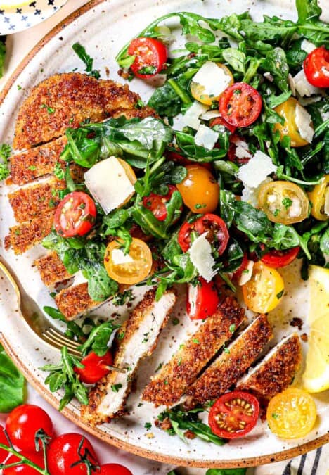 top view of chicken Milanese topped with arugula salad