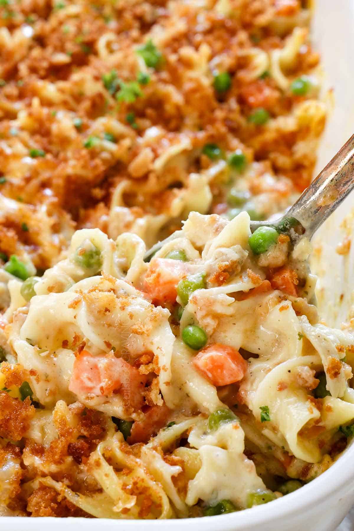 up close of scooping chicken and noodle casserole showing how creamy it is