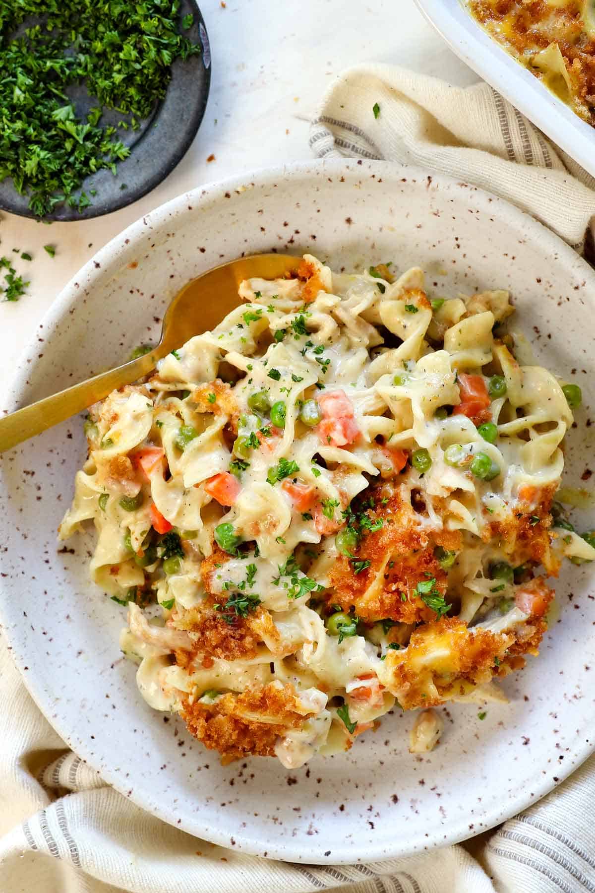 top view of serving chicken casserole with noodles in a bowl garnished by parsley