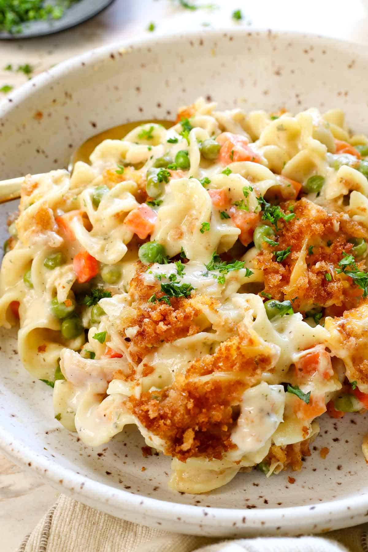 chicken noodle casserole recipe being served on a plate garnished with parsley