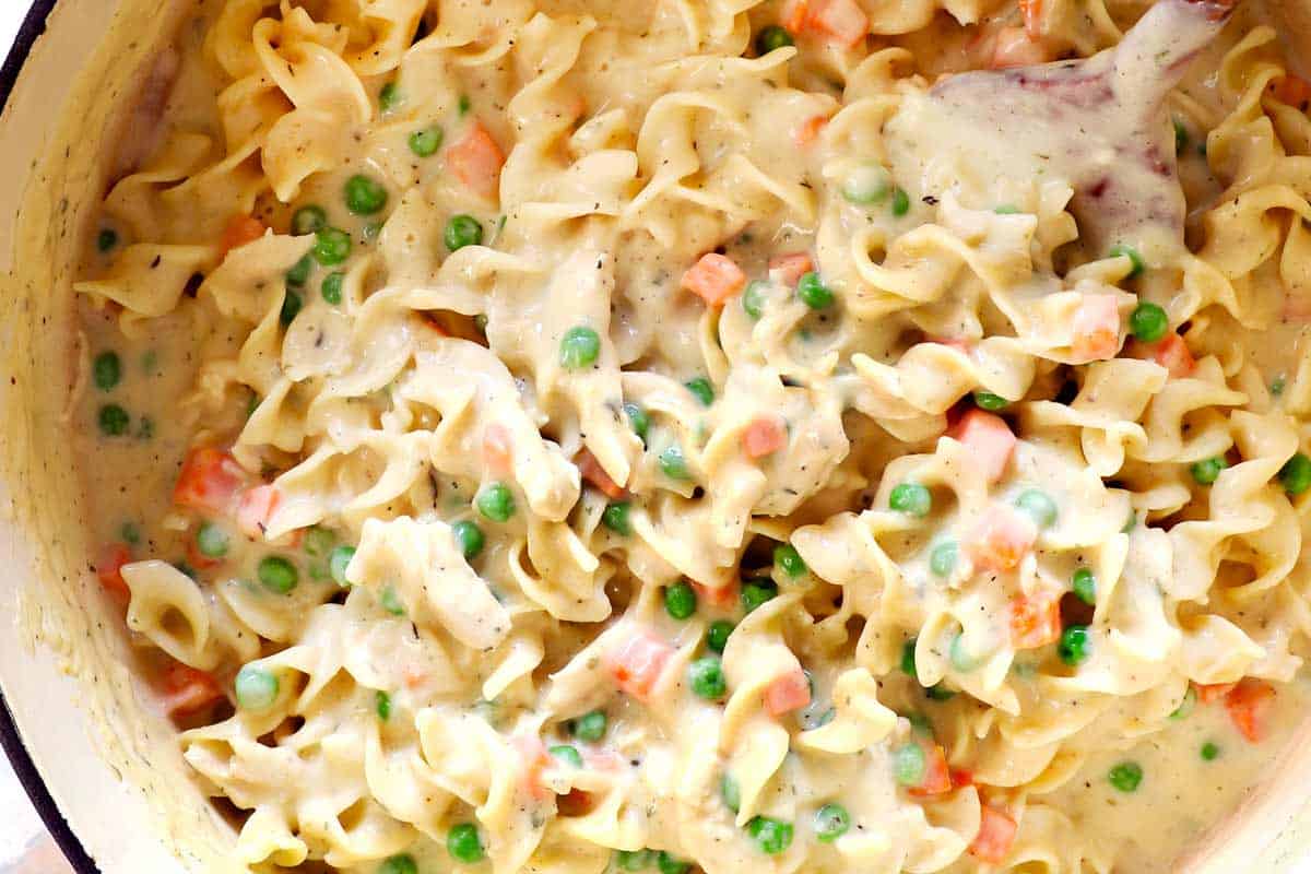 showing how to make chicken noodle casserole by folding in the noodles, showing how creamy it is