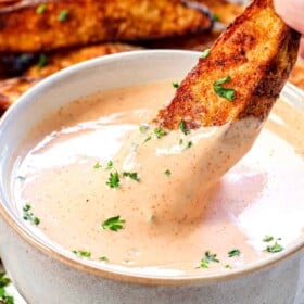 up close of dipping French fries in fry sauce showing how thick and creamy it is
