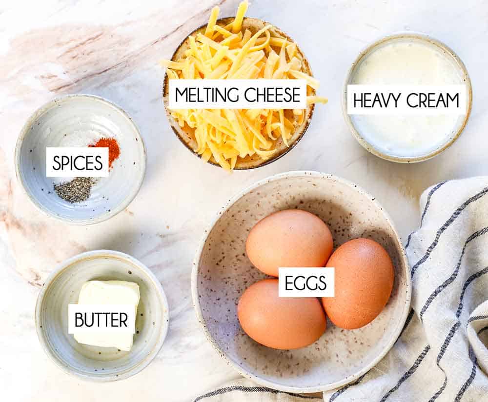 top view of omelette ingredients: eggs, cheese, heavy cream, salt, pepper and butter
