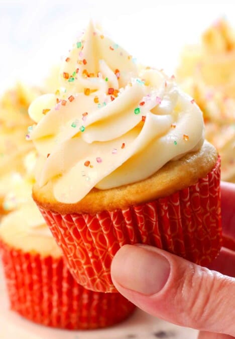 holding up a vanilla cupcakes cupcake showing the frosting